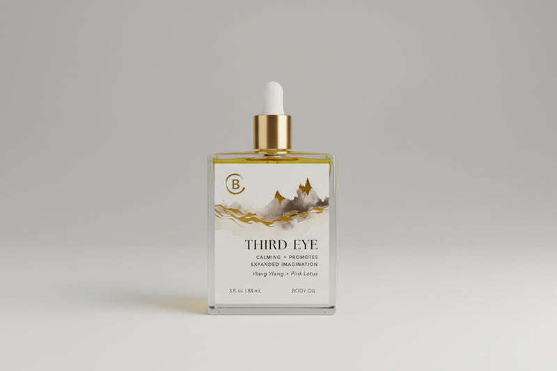 Bottle of Third Eye body oil with a gold dropper on a dark surface.