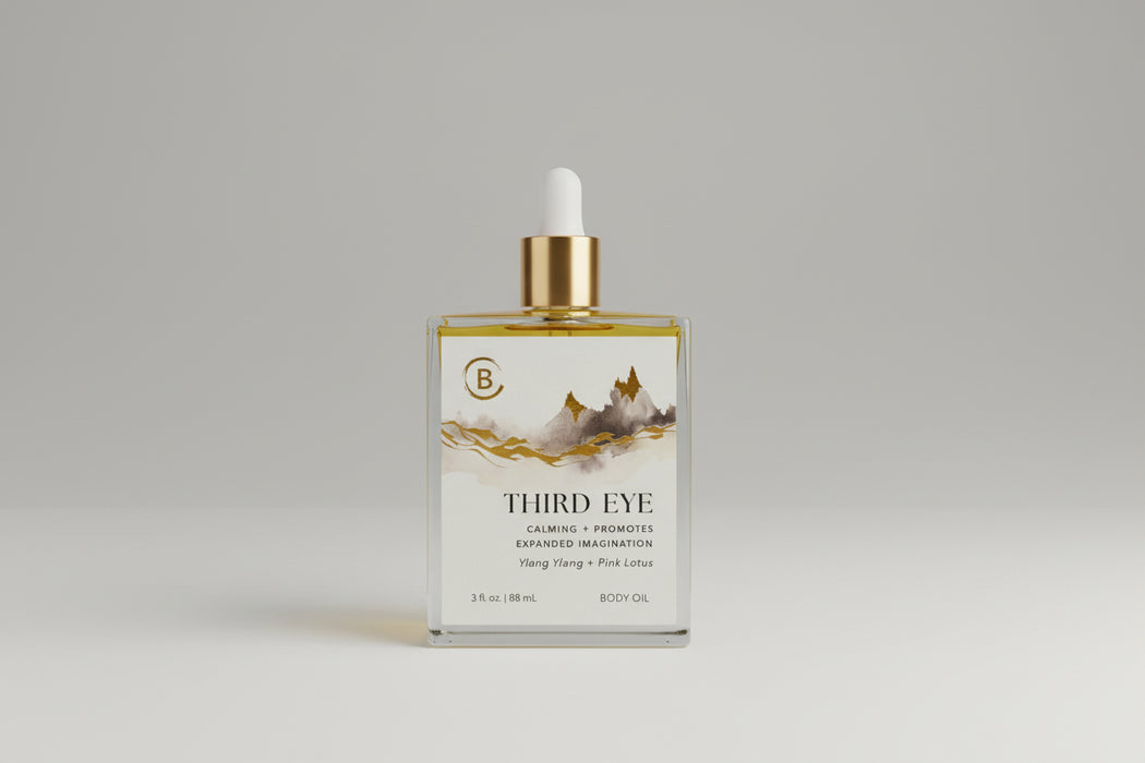 Bottle of Third Eye body oil with a gold dropper on a dark surface.