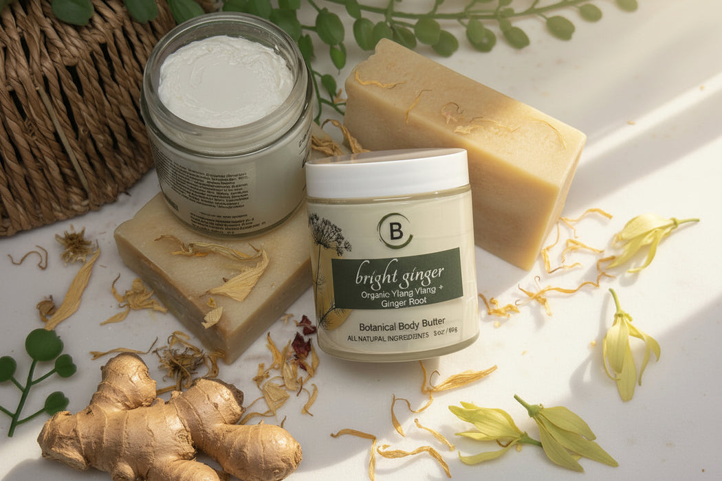 Two jars of 'Bright Ginger' botanical body butter and a bar of soap on a textured surface with greenery.