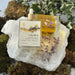 2 Crown Body Oil bottles on Crystal with Amethyst , moss and ivy surrounding it