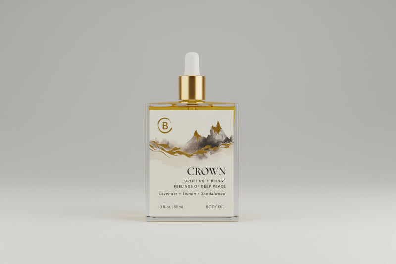 Bottle of Crown body oil with a dropper on a marble surface