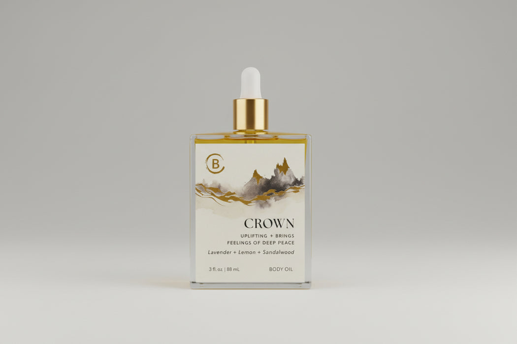 Bottle of Crown body oil with a dropper on a marble surface