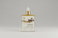 Bottle of Crown body oil with a dropper on a marble surface