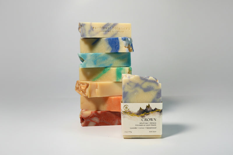 Stack of colorful soap bars with a single labeled Crown bar soap a gray background