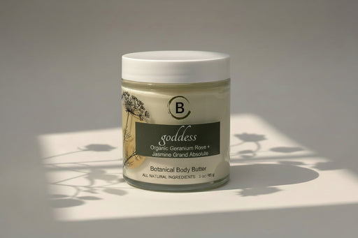 Jar of 'goddess' botanical body butter with a white label on a light background