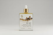 Body oil bottle with dropper labeled 'Heart' on a reflective surface.