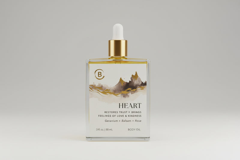 Body oil bottle with dropper labeled 'Heart' on a reflective surface.