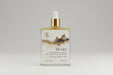 Body oil bottle with dropper labeled 'Heart' on a reflective surface.