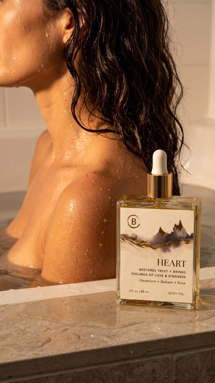 Perfume bottle labeled 'Heart' on a bathtub ledge with a person in the background.