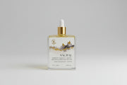 Body oil bottle labeled 'Sacral' with a dropper on a textured surface.