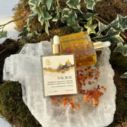 Two bottles of 'Sacral' product on a crystal with nature elements