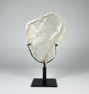 Large Gypsum Selenite on a black stand against a gray background