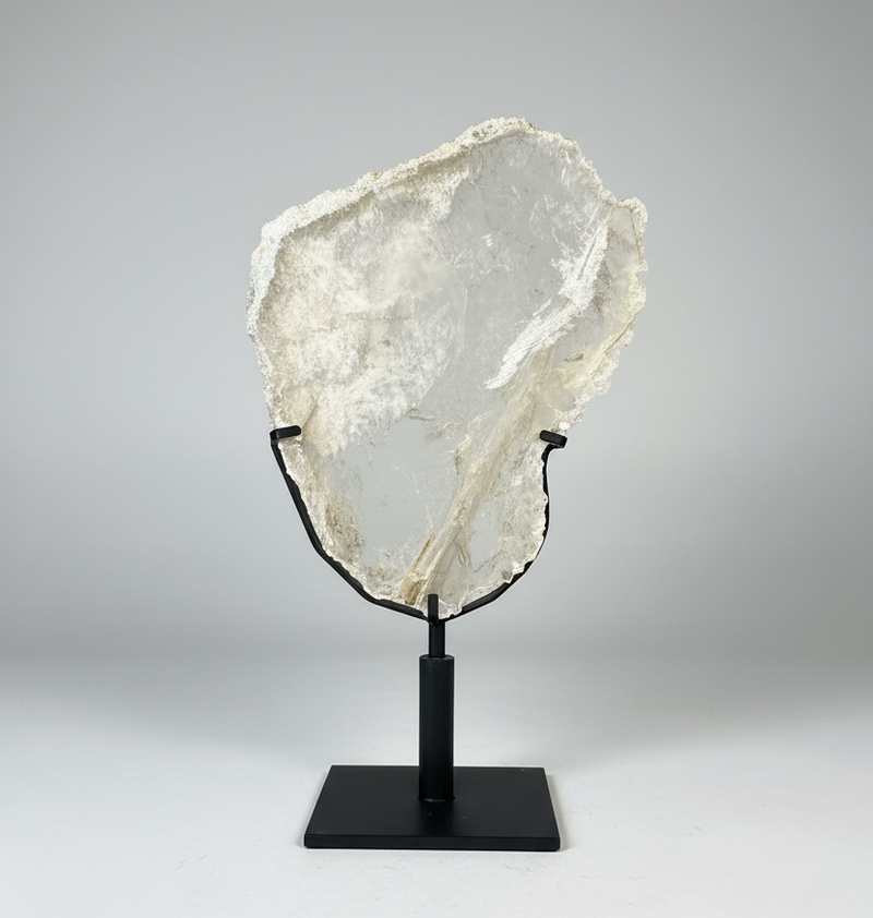 Large Gypsum Selenite on a black stand against a gray background