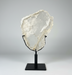 Large Gypsum Selenite on a black stand against a gray background