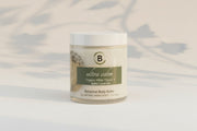 Jar of 'ultra calm' botanical body butter on a marble surface with a light gray background.