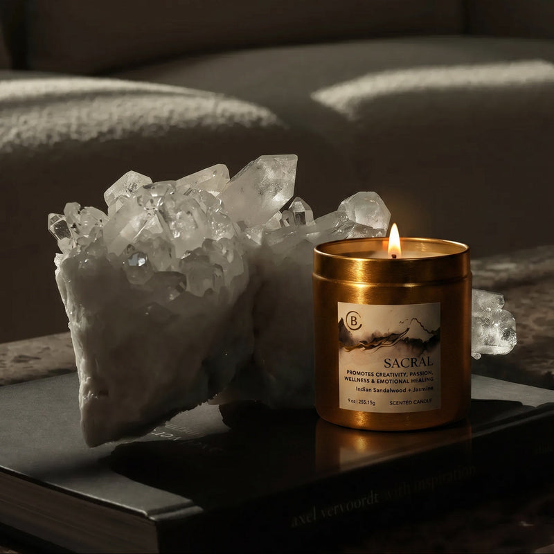 Candle with a label on a surface next to crystals and a blurred background