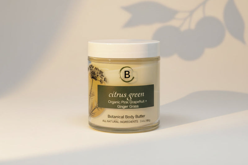 Jar of botanical body butter labeled 'citrus green with light gray background.