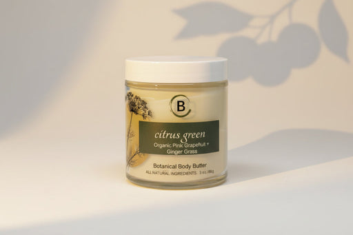 Jar of botanical body butter labeled 'citrus green with light gray background.