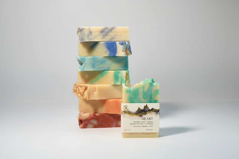 Stack of colorful soap bars with Heart single bar in front on a gray background