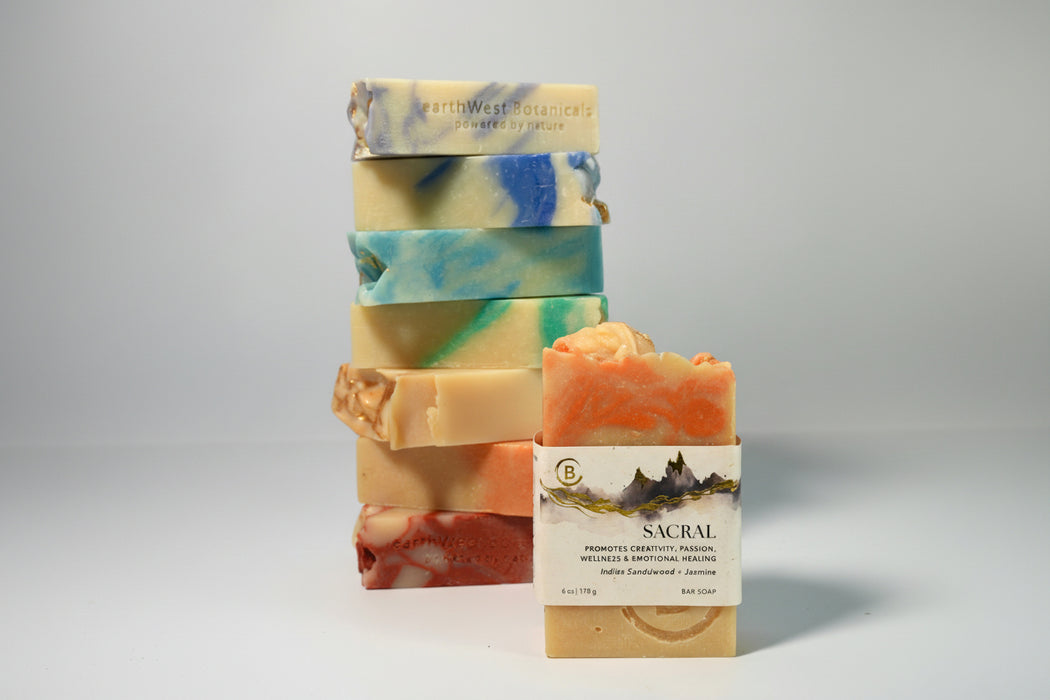 Stack of colorful soap bars with a box labeled 'Sacral' on a gray background